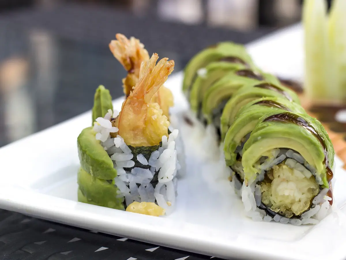 Avocado shrimp tempura maki rolls drizzled with sweet soy glaze on square plate at Cucumber Sushi, a Japanese Restaurant in Jersey City